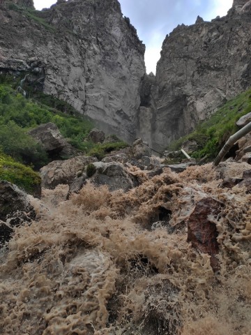 Фото водопада, вода размывает грунт и имеет бурый цвет